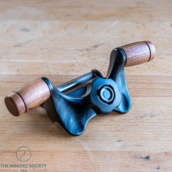 Kakuri honing guide with walnut handles on wooden workbench – front angled view