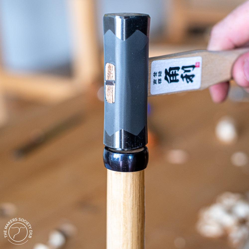Kakuri Square-Head Hammer 225g Silver color in action tapping on a Japanese chisel sold by The Makers Society Dubai