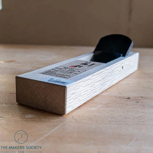 Kakuri 60mm smooth plane with white oak body on wooden workbench – hand plane front view