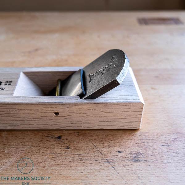 Kakuri 60mm Japanese smoothing plane showing forged steel blade and oak dai body – close-up