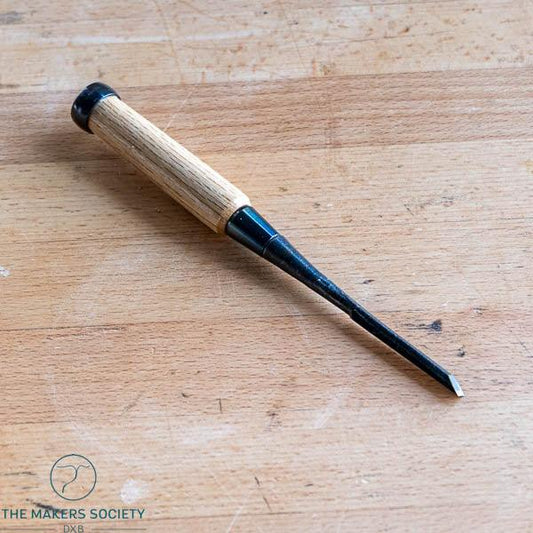 Kakuri 6mm Japanese wood chisel made of white steel with oak handle on wooden workbench