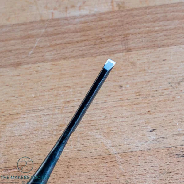 Close-up of Kakuri 6mm white steel chisel blade showing sharp laminated edge and black ferrule