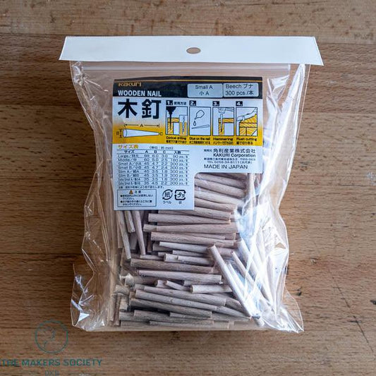 Bag of Kakuri wooden nails small size beech wood 300 pieces made in Japan on wooden surface