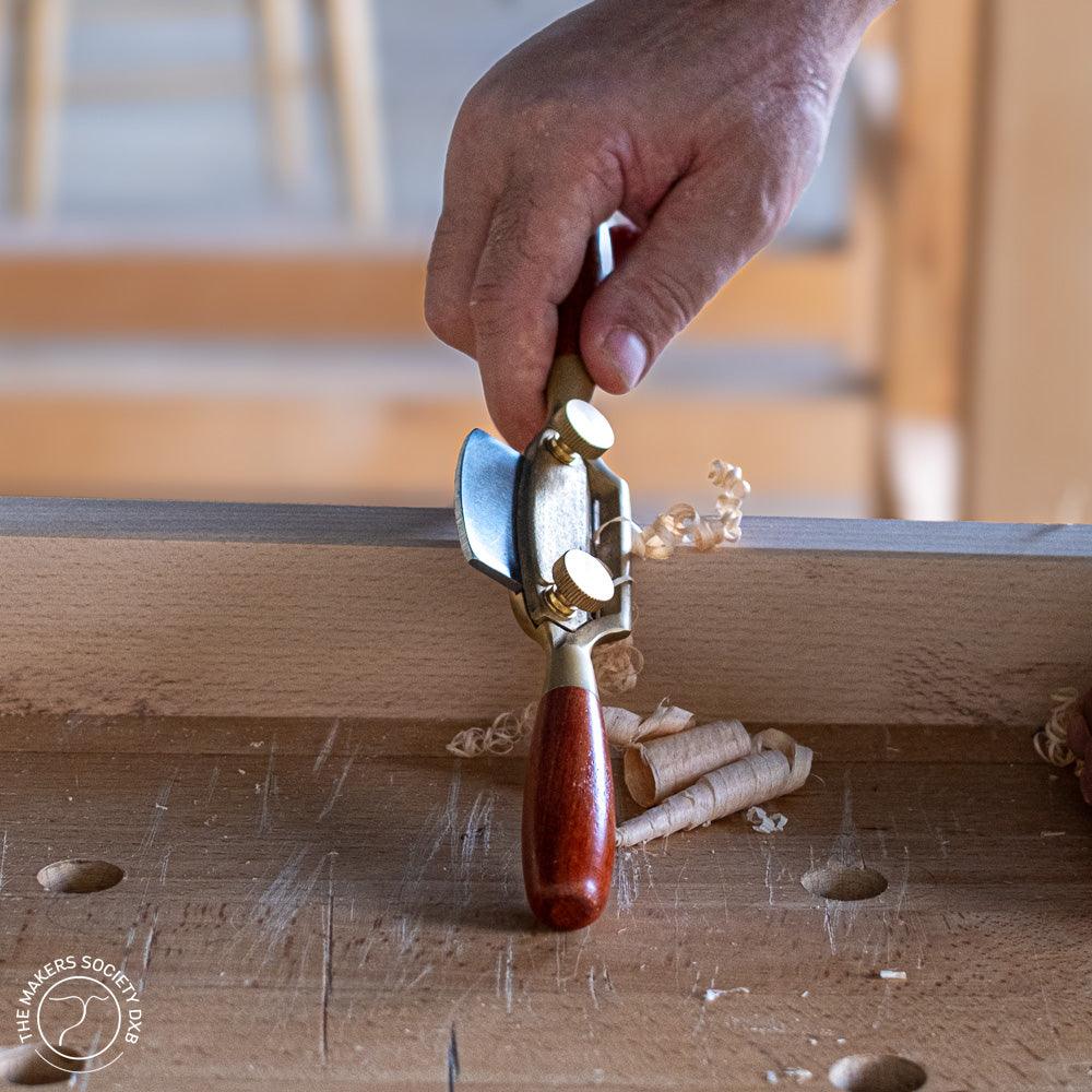 Luban Bronze Spokeshave with flat sole in action while cutting sold by The Makers Society Dubai