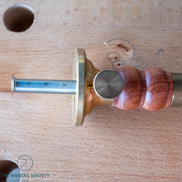 Close-up of the graduated steel rod and brass face of the Luban marking gauge