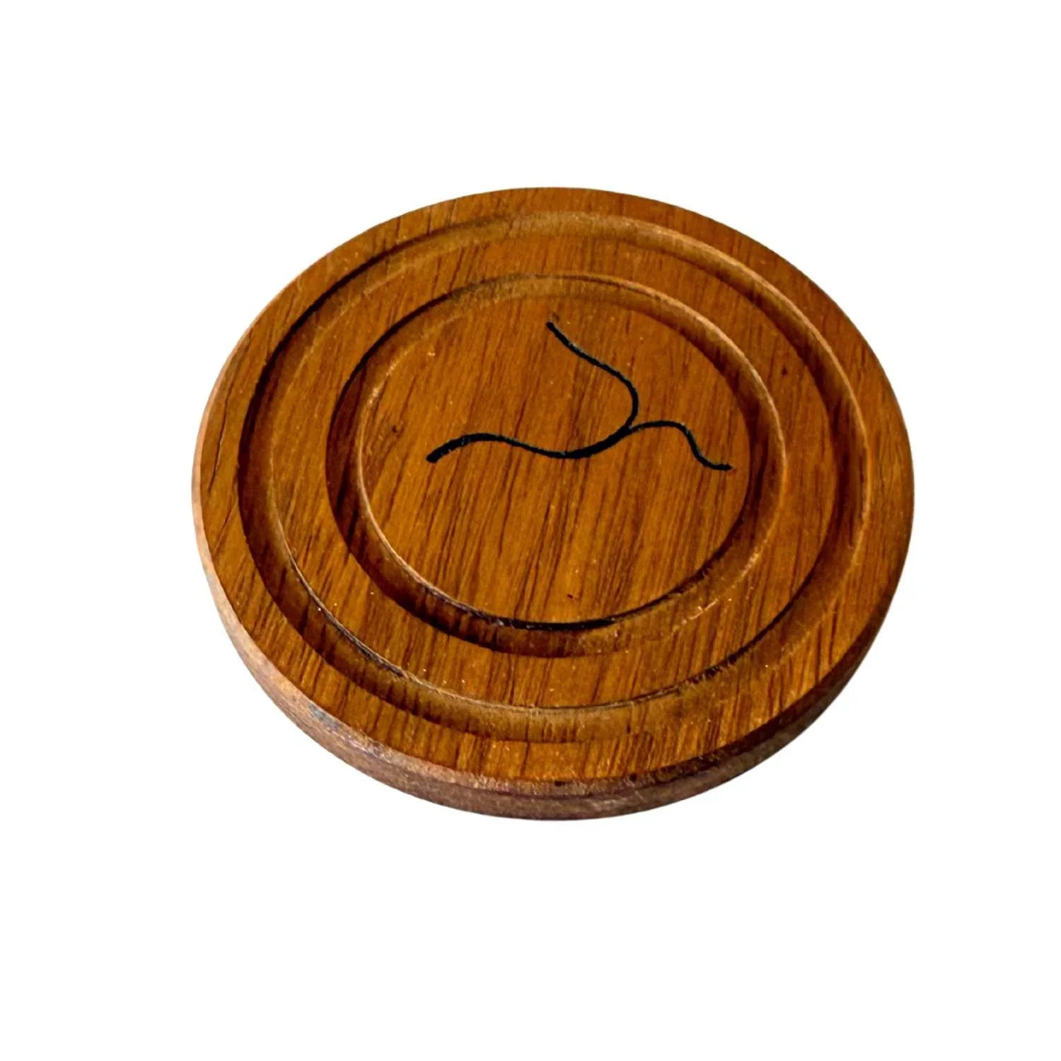 Round wooden coaster with carved concentric circles and a black abstract line design