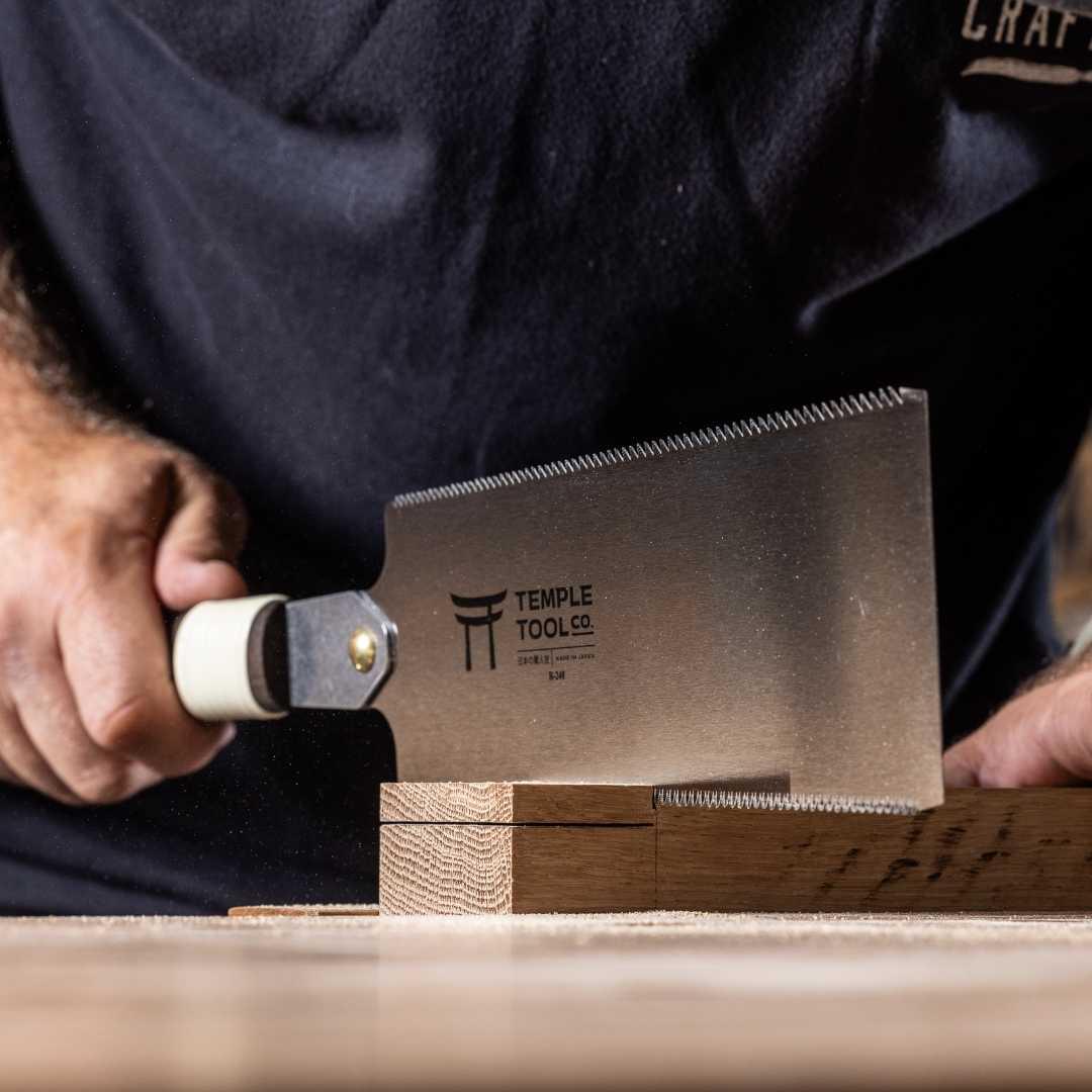 Temple Tool Ryoba saw 240mm cutting wooden plank held by person in black shirt