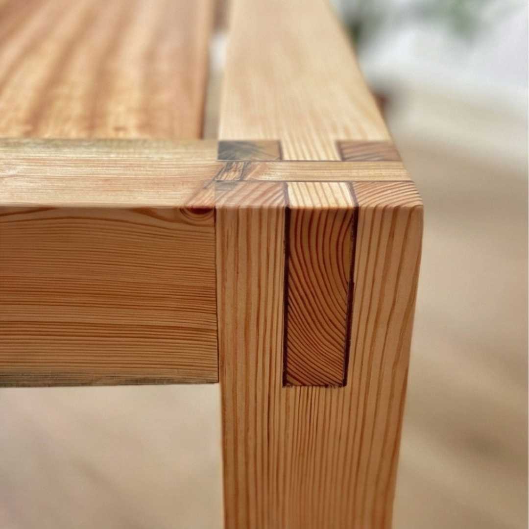 Close-up of a wooden bench with a blurred natural background