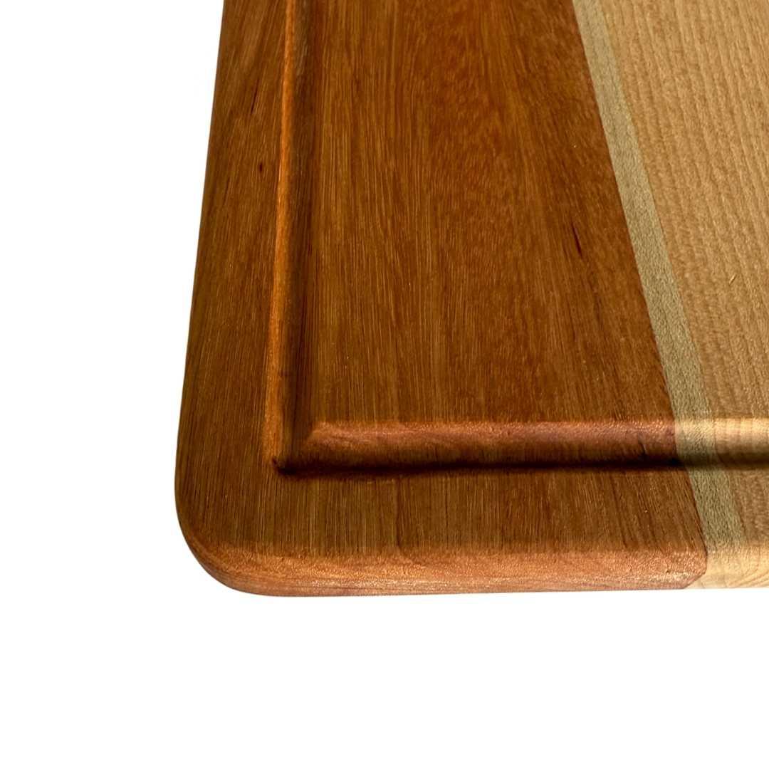 Close-up of a wooden cutting board with long grain and groove edge detail