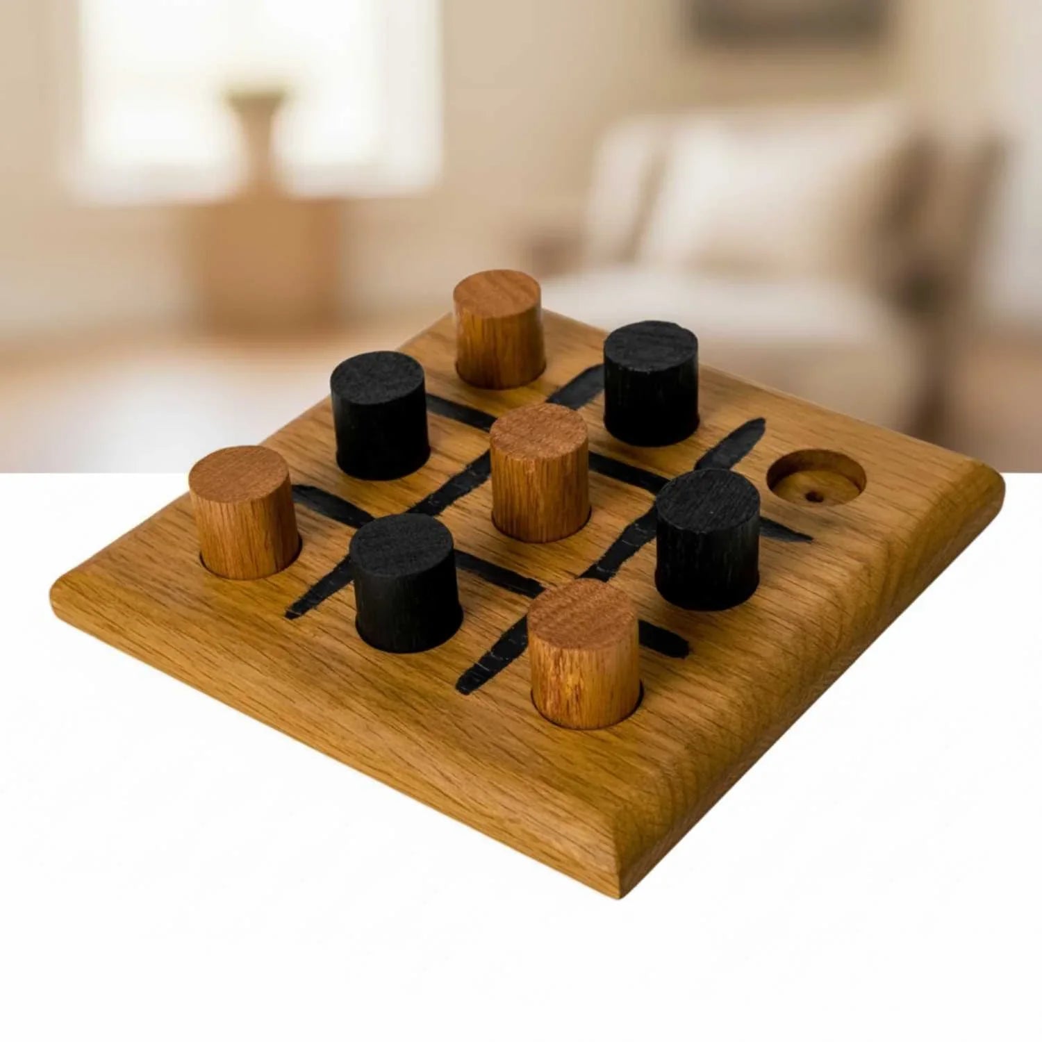Wooden tic-tac-toe game set with black and brown pieces on a blurred background